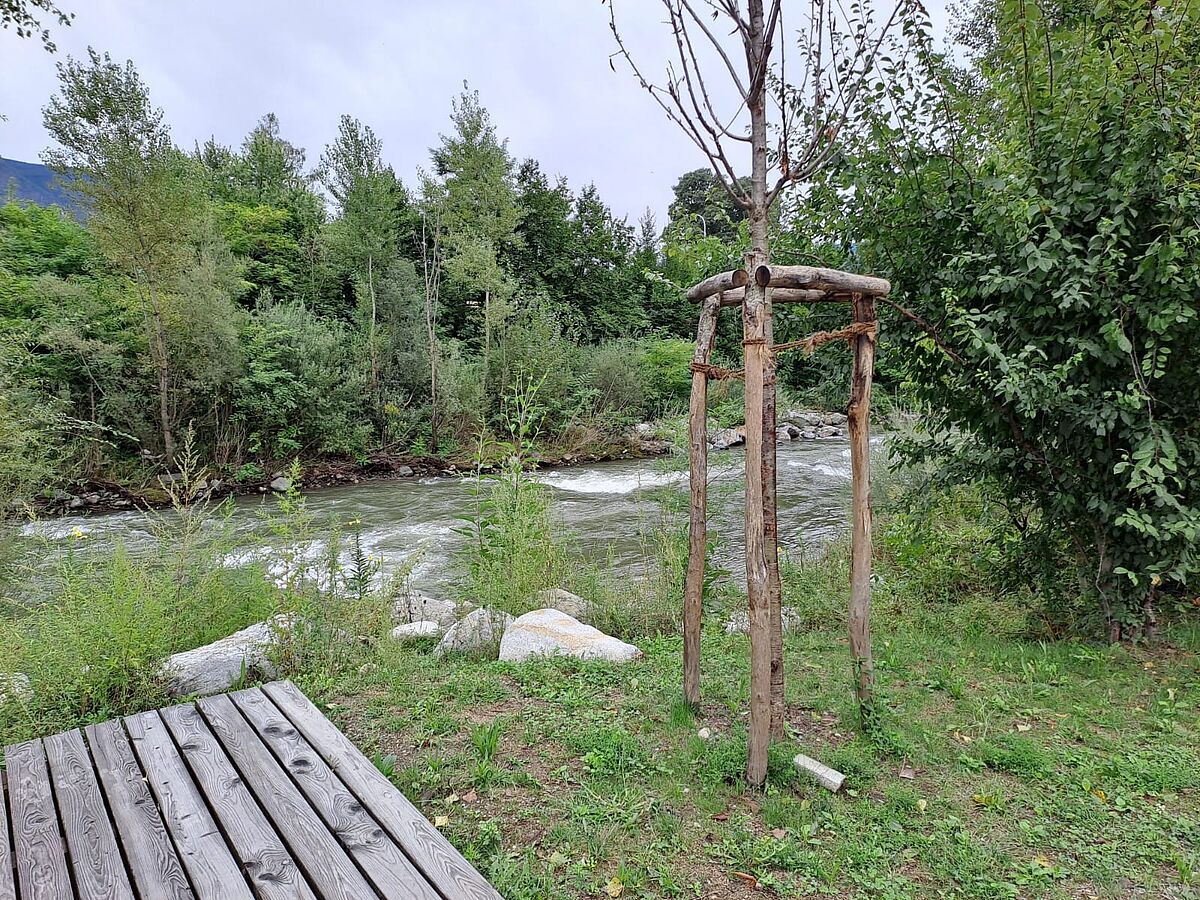 Der Flusspark erstreckt sich entlang der Passer und säumt den Fluss mit Sitzgelegenheiten aus Holz.